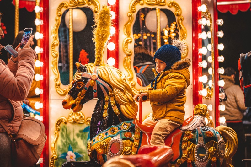 Little boy riding a carousel