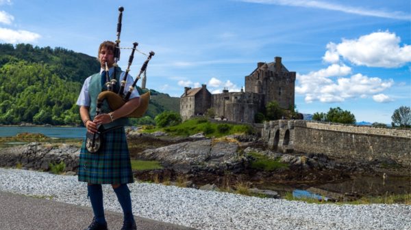 Castle and Scottish pipe musician in Scotland