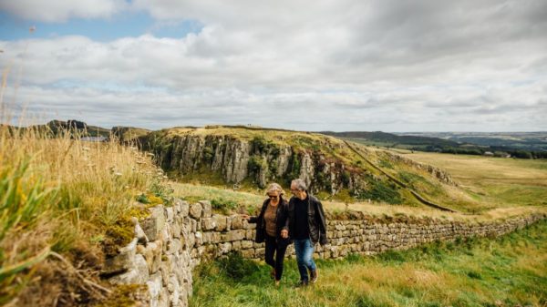 A couple strolling along Hadrian's Wall, North East England